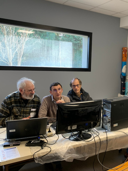 photo de trois personnes penchées au dessus d'un appareil démonté